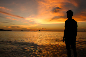 silhouette of man at sunset on the beach