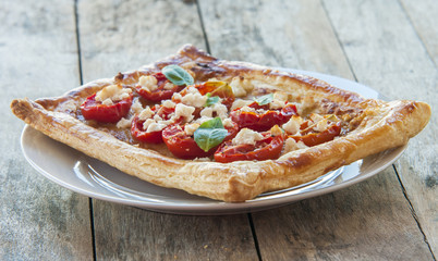 Tomato tart, puff pastry topped with mustard, cheese and cherry toamtoes.