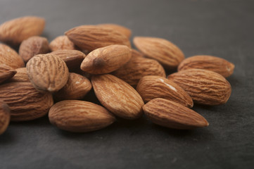 Almonds in a black plate. Close-up.