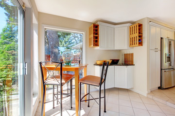 Light tones dining room with brown table set and tile floor.