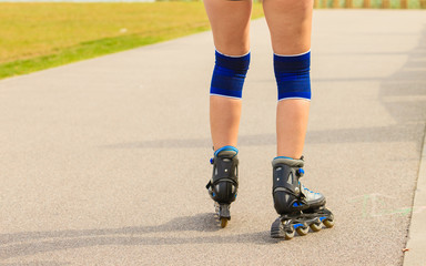 Fototapeta na wymiar Young woman rollerblading outdoor on sunny day