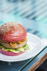 modern gourmet chicken burger in beetroot bun