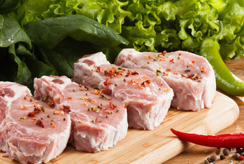 Raw steak with vegetables, spices and herbs