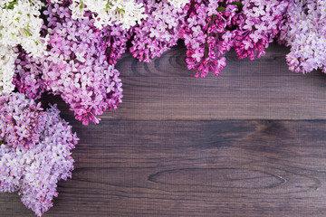 The beautiful lilac flowers on a dark wooden background