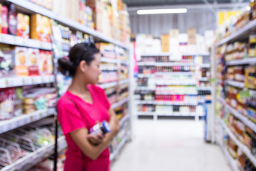 The blurred of picture woman is shopping in the supermarket.