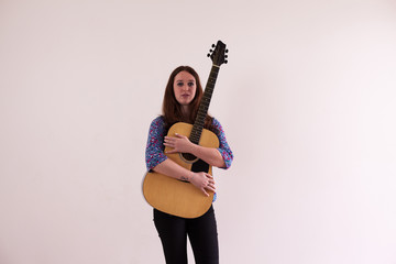 view young ginger woman playing with her guitar