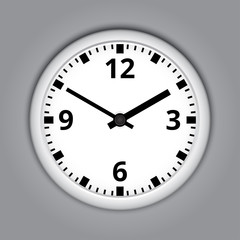 Round wall clock on grey background.