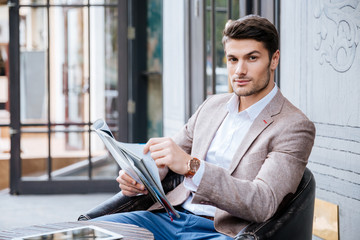 Man in suit sitting at table in cafe outdoors
