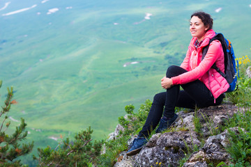 Naklejka na ściany i meble Woman Hiker with backpack relaxing on top of a mountain and look