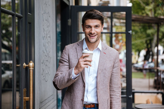 Young business man drinking a cup of coffee outdoors