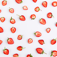 Colorful pattern of strawberry halves on a white background. Top view with copyspace