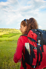 Tourist girl enjoying view of beautiful dry green wheat hills