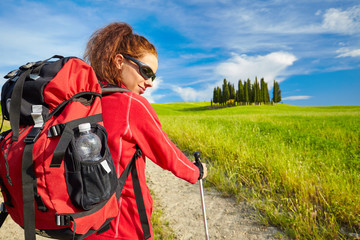 Tourist girl enjoying view of beautiful dry green wheat hills