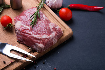 Raw beef steak and spices on the wooden board