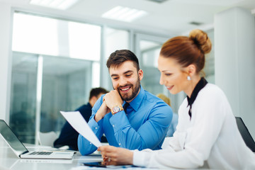 Young business people look at paper document