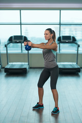 Fitness Woman Using Kettlebells Inside Gym