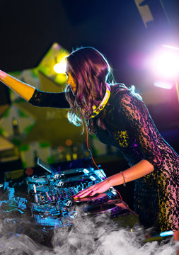 Disc jockey girl mixing electronic music in club