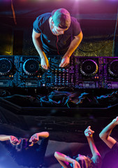 Disc jockey mixing electronic music in club - obrazy, fototapety, plakaty