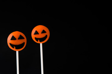 Halloween cake pops with pumpkin shape on black background

