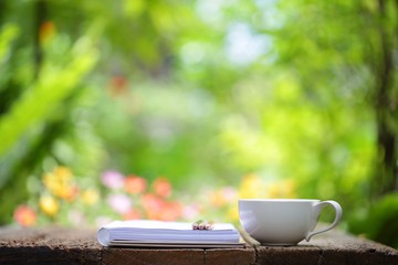 Notebook with pencil and cup on wooden table