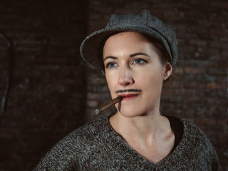 Portrait einer jungen Frau mit Zigarre, die als Mann verkleidet