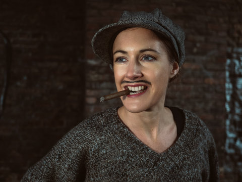 Portrait einer jungen Frau mit Zigarre, die als Mann verkleidet