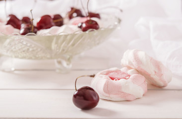 Marshmallows and cherries in a crystal vase on a white background 