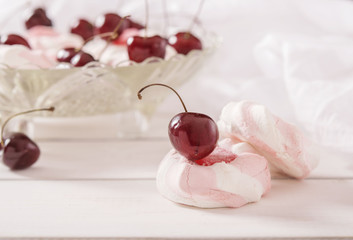 Fototapeta na wymiar Marshmallows and cherries in a crystal vase on a white background 
