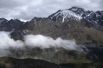 Fototapeta na wymiar Clouds Flying Between Mountains Russia, Caucasus.