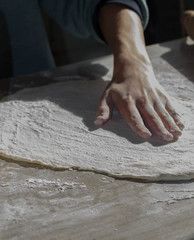 Man kneading dough on the kitchen table