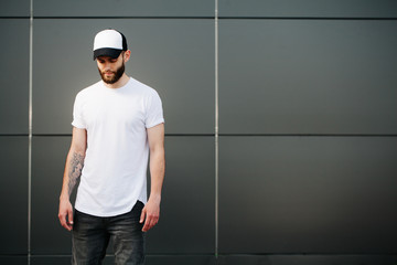Hipster wearing white blank t-shirt and a baseball cap with spac