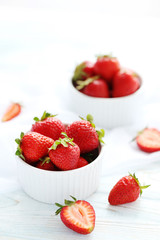 Strawberries in bowl on white wooden table