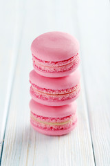Tasty pink macarons on a blue wooden table