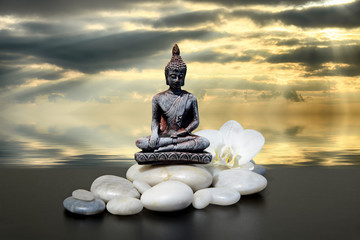 Zen or Feng-Shui background-Buddha,zen stone,white orchid flowers and dark sky and clouds reflected in water