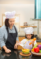 Asian mother teaching daughter making salad in kitchen,Cooking  concept of happy asian little girl and mother making salad 