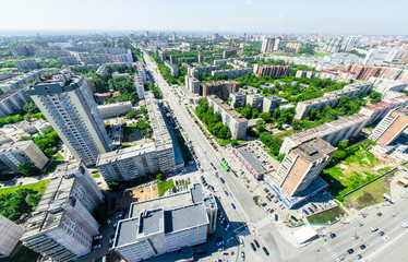 Aerial city view with crossroads and roads, houses, buildings, parks and parking lots, bridges. Urban landscape. Copter shot. Panoramic image.