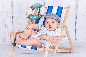 Funny little toddler sitting on the deckchair