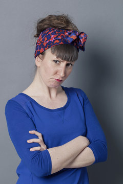 angry young woman looking mad, standing with arms folded