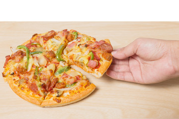 hand holding tasty flavorful pizza on wood