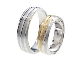 Two wedding rings standing next to each other isolated on white