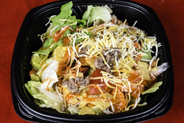 fresh taco salad of seasoned ground beef lettuce tomato and grated cheese
