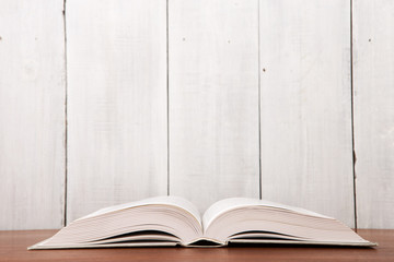 Open book on the desk over wooden background