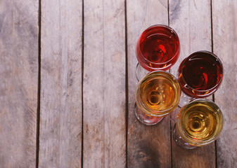 Glasses with wines of different colors on a wooden table