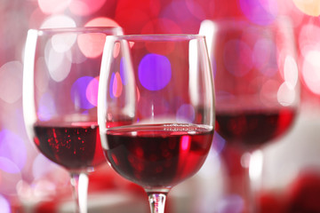 Wineglasses on red blurred lights background