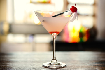 Glass of cocktail on bar background