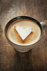 Cup of coffee with marshmallow on wooden table