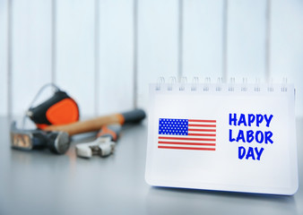 Notebook with printed text HAPPY LABOR DAY on grey table closeup