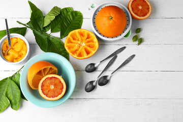 Eating oranges with spoon on white wooden table
