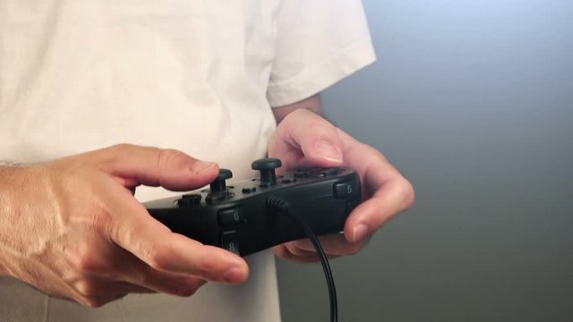 Man using game pad controller to play entertaining electronics video games, gaming and entertainment concept