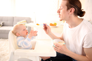 Father feeding his baby son